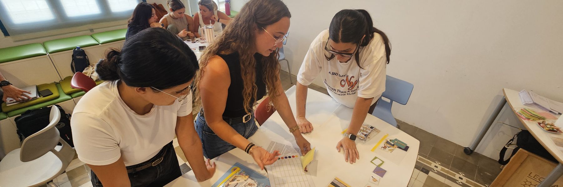 Docents preparant material didàctic damunt una taula durant una formació